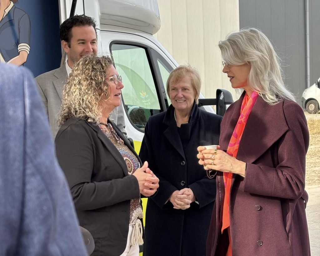 Mona Keijzer (rechts) in gesprek met een medewerker van de gemeente. Op de achtergrond staan wethouders Mark Versteeg en Mary van Gent.