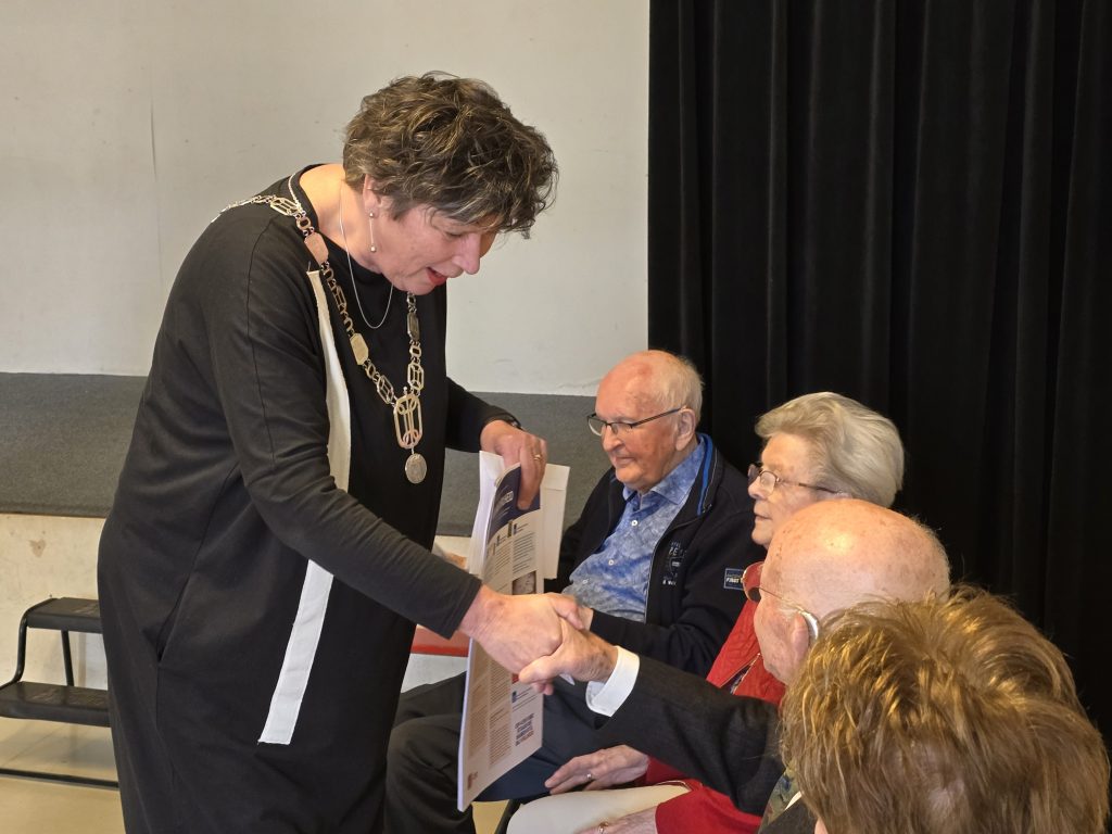 Burgemeester schudt de hand van inwoner Hollands Kroon.