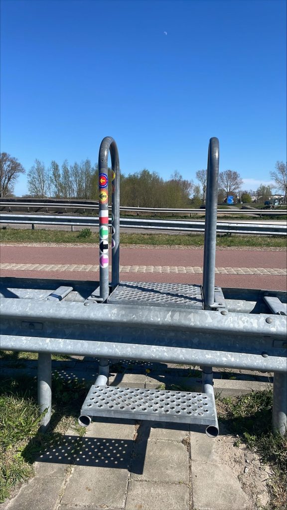 Stickers van wandelroutes op een trappetje over een vangrail.
