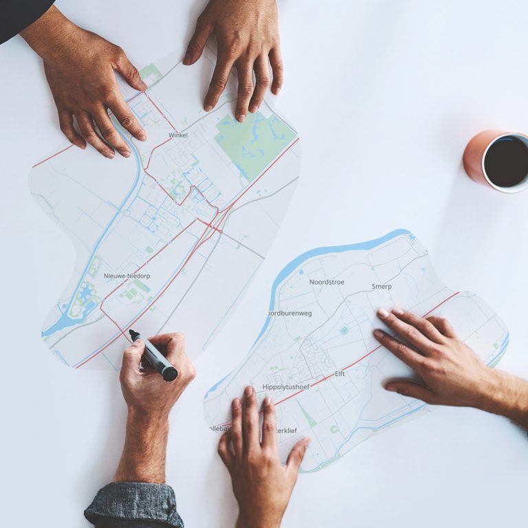 Dorpsvisie Nieuwe Niedorp, Winkel en Hippolytushoef. Foto van een kaart op tafel van deze drie gebieden met handen die erop rust en iets tekenen.