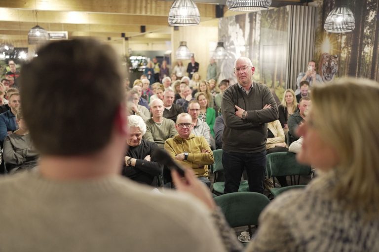 Netwerkbijeenkomst voor organisatoren van evenementen. Foto van twee sprekers voor een zaal met inwoners van achteren gezien
