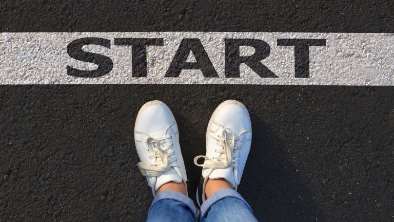 Twee voeten staan voor een startstreep waar start op staat