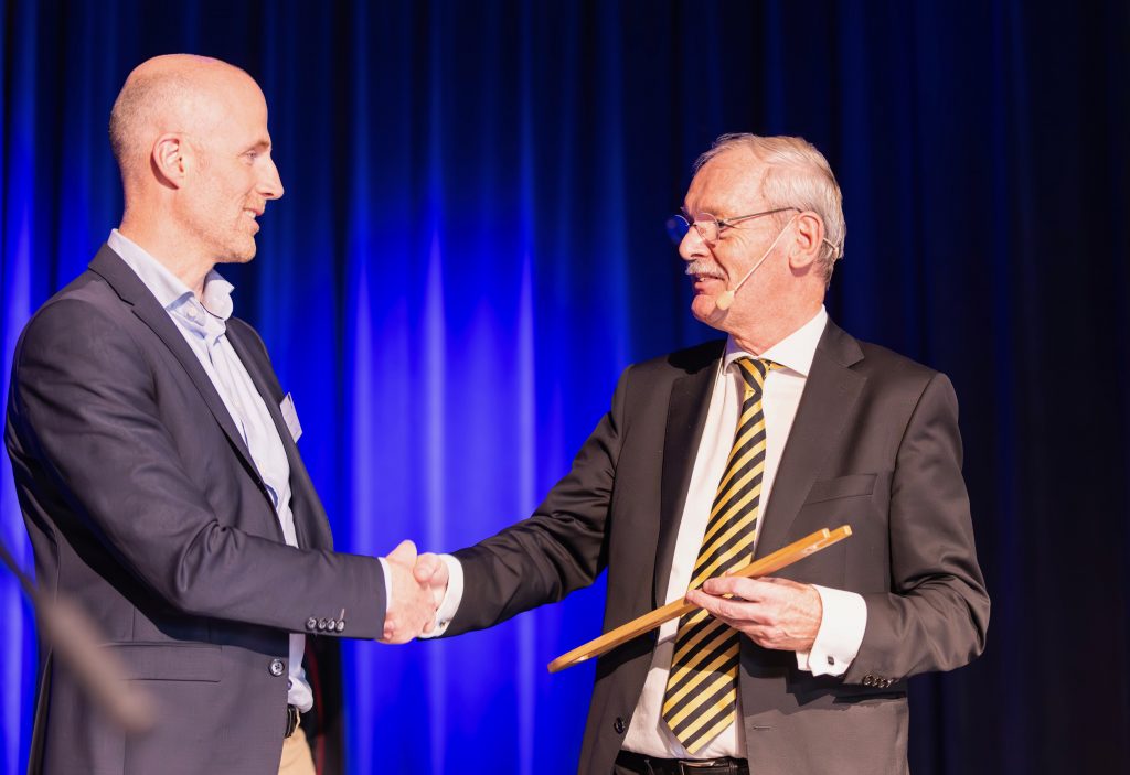Staatssecretaris Rummenie (rechts) overhandigde de houten boetnaald aan wethouder Robert Leever