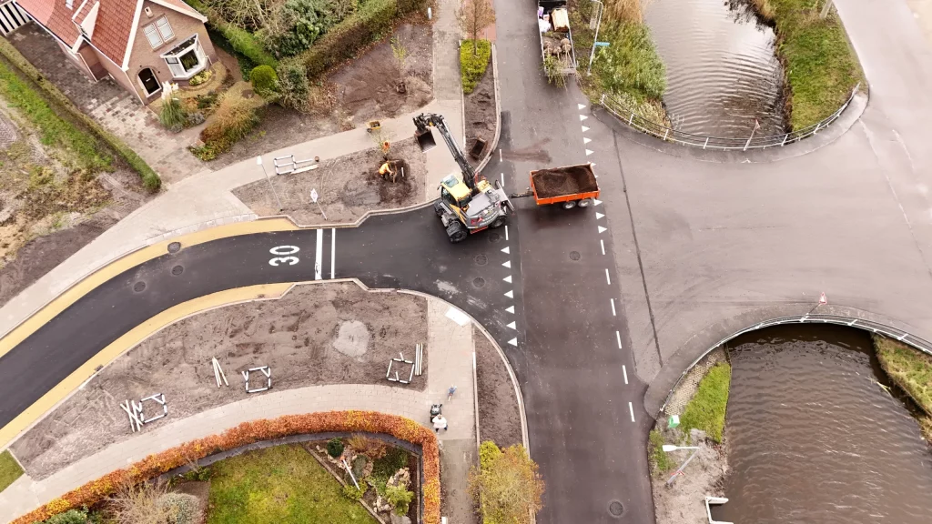 Overzicht van het kruispunt van boven gezien met een graafmachine die aan het werk is