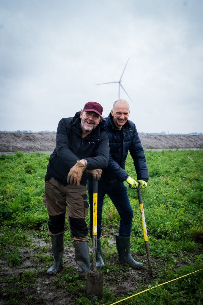 Twee mannen leunen even op de schop