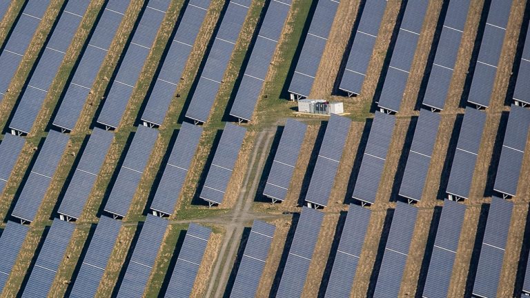 Foto van een hoop zonnepanelen in rijen op een akker