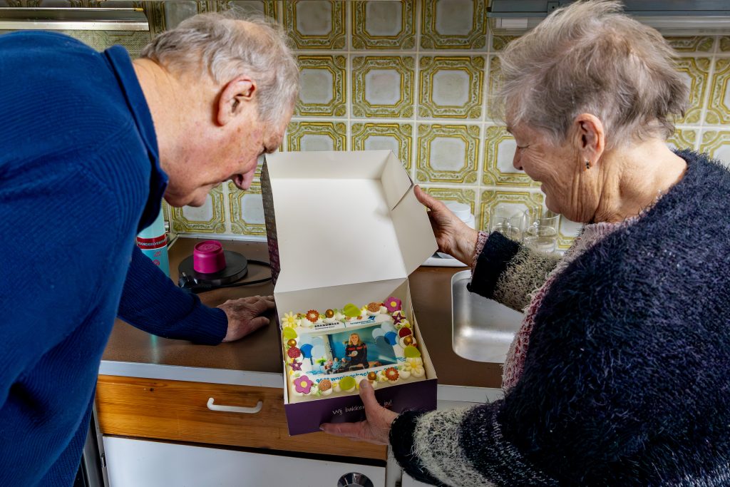 900e woningcheck van 2025 in winkel. Bewoner ontvangt een taart met daarop een foto van de brandweer