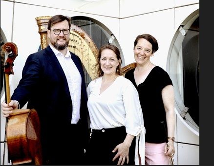 Kroonconcert bij kaarslicht de drie muzikanten met hun instrumenten poseren naast elkaar