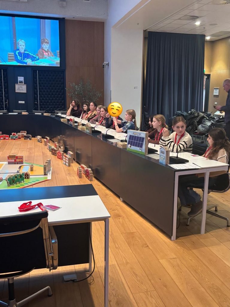 Leerlingen van basisschool in raadszaal volgen het educatieve simulatiespel Democracity.