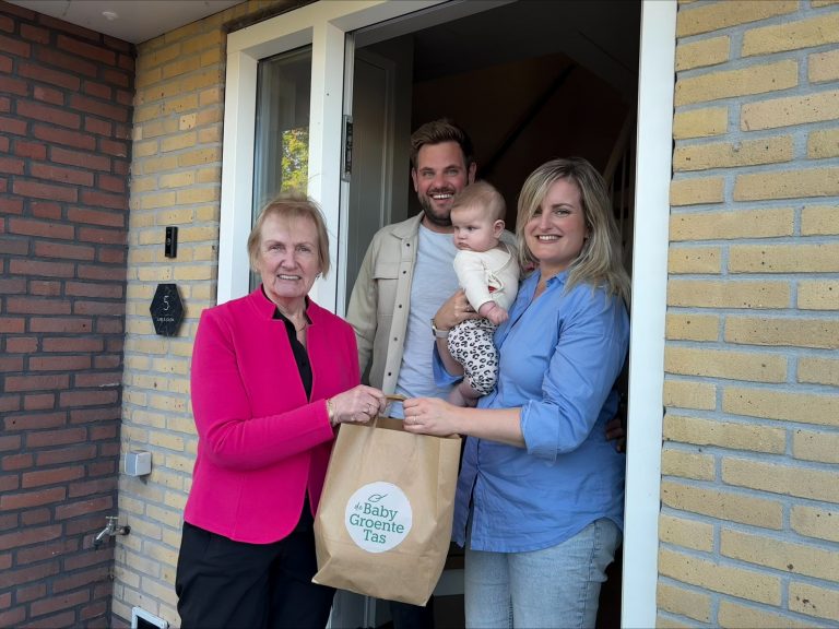 Gezin samen met Mary ontvangt de baby groente tas