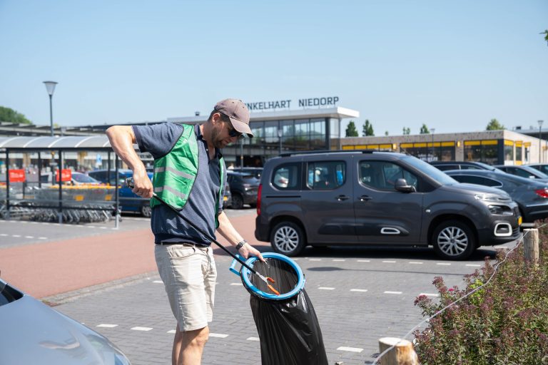 Collega ruimte vuilnis op in de openbare ruimte tijdens Hollands Kroon in 1 dag schoon
