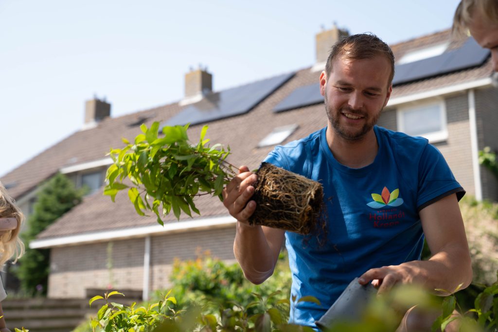 Collega plant plantjes in de openbare ruimte tijdens Hollands Kroon in 1 Dag Schoon