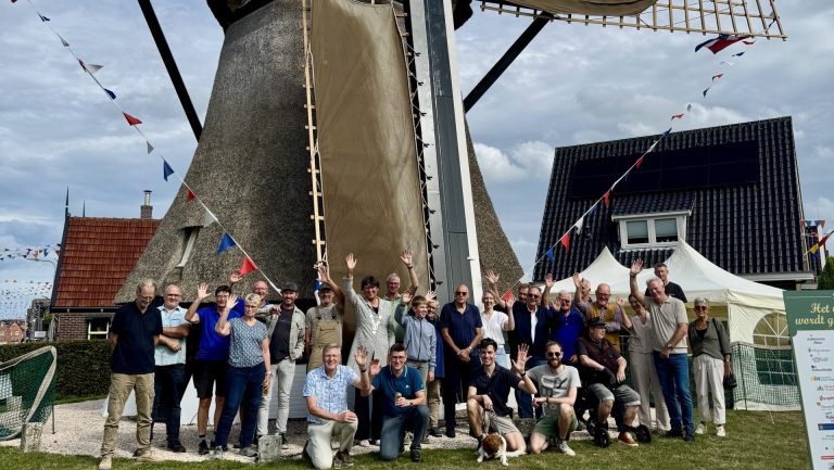 Groepsfoto met burgemeester Rian van Dam voor molen de Hoop in Den Oever