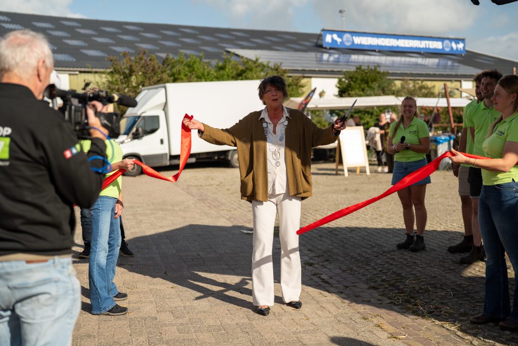 Rian van Dam knipt het lintje door en opent daarmee de Boerenversmarkt