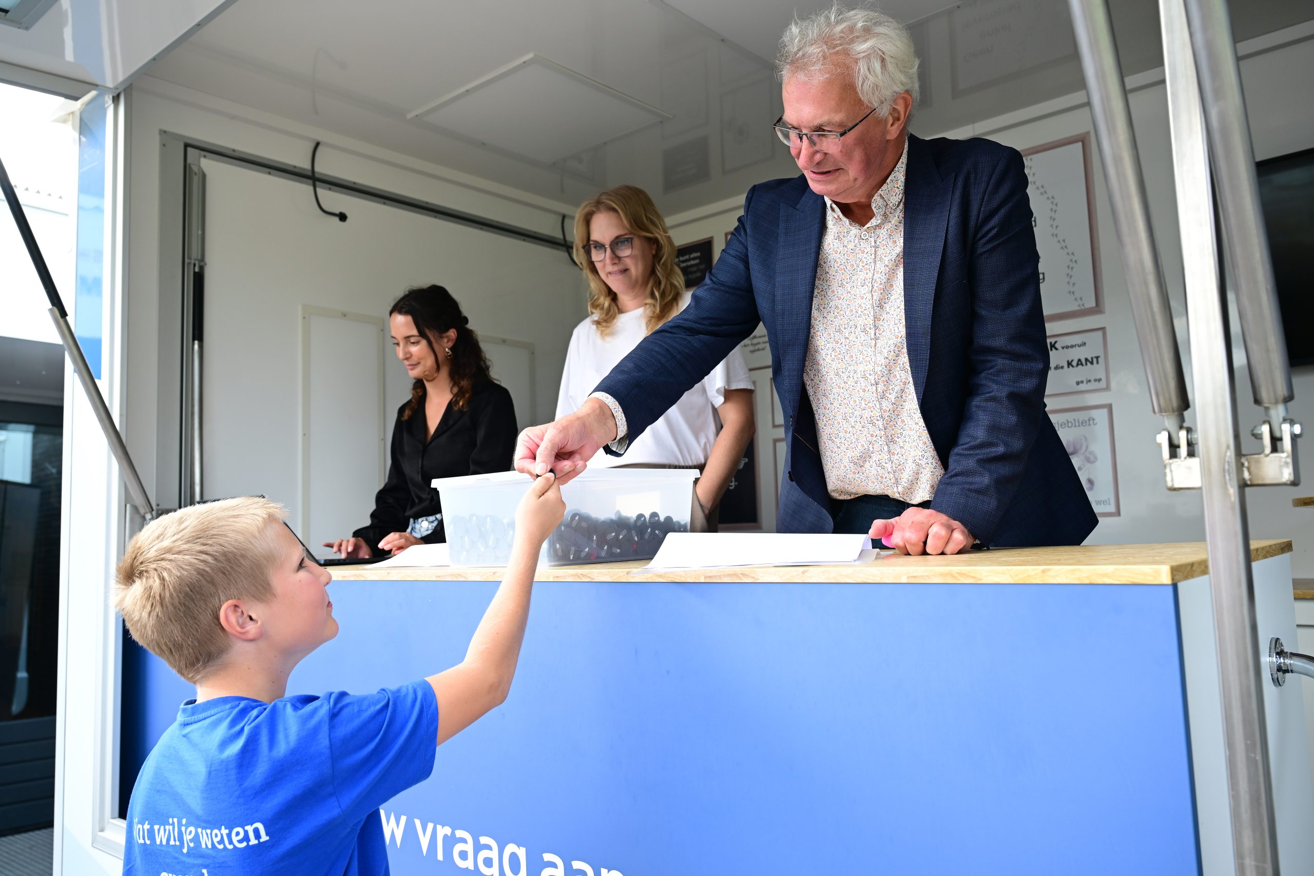 Martin Scholten deelt muntjes uit waarmee verspakket kan worden afgehaald